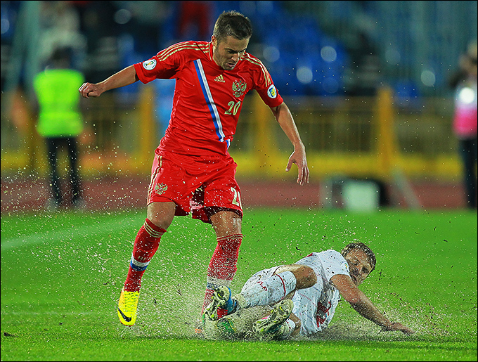Виктор Файзулин уходит от подката соперника на размытом дождём поле