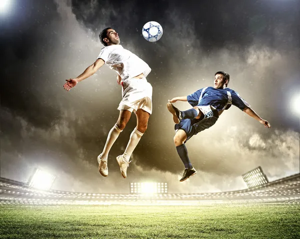Два футболиста, ударяющие шар Стоковое Изображение