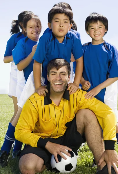 Мультиэтнические дети с тренером футбола Лицензионные Стоковые Изображения