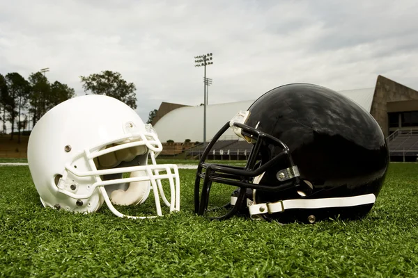 Черный и белый футбольные шлемы Стоковое Фото