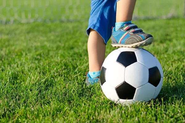 Мальчик с его ногой на футбольный мяч Лицензионные Стоковые Фото