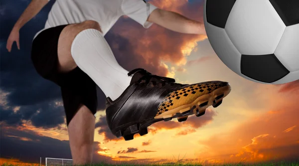 Футболист в белом ударе ногой — стоковое фото