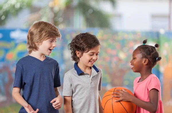 Дети, играть в баскетбол в школе Лицензионные Стоковые Фото