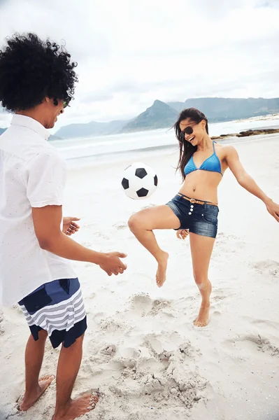 Latino пара играть в футбол на пляже Стоковое Изображение