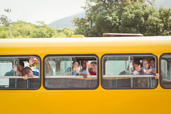 Симпатичные учеников, улыбаясь в камеру в школьный автобус Стоковое Фото
