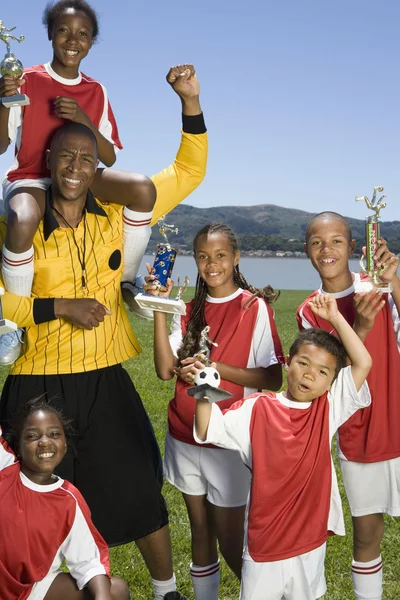 Мультиэтнические дети, держащие трофеи футбола Стоковая Картинка