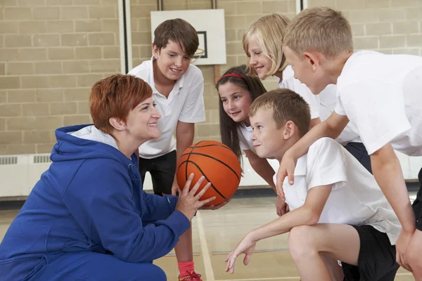 Тренер дает команду говорить для начальной школы по баскетболу Лицензионные Стоковые Фото