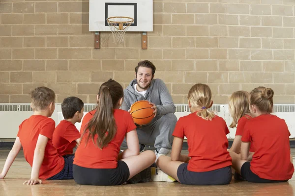 Тренер дает команду говорить для начальной школы по баскетболу Стоковое Изображение