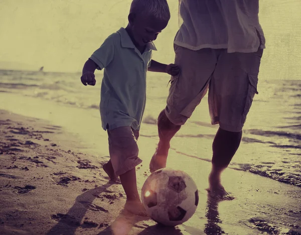 Отец и сын, играя футбол концепции Стоковая Картинка