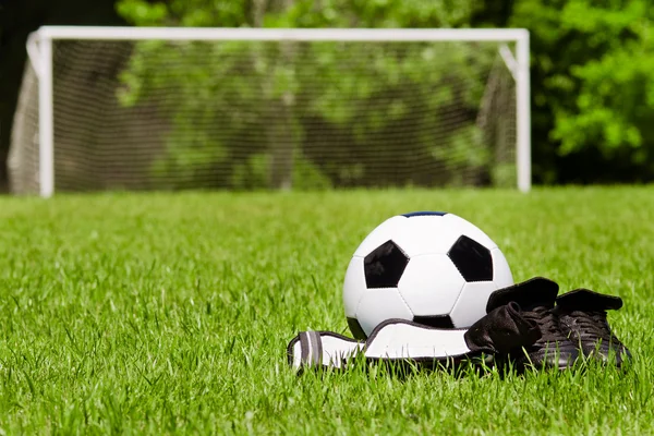 Детей спортивным концепт с футбольный мяч, бутсы, голени охранников на поле с копией пространства Стоковая Картинка
