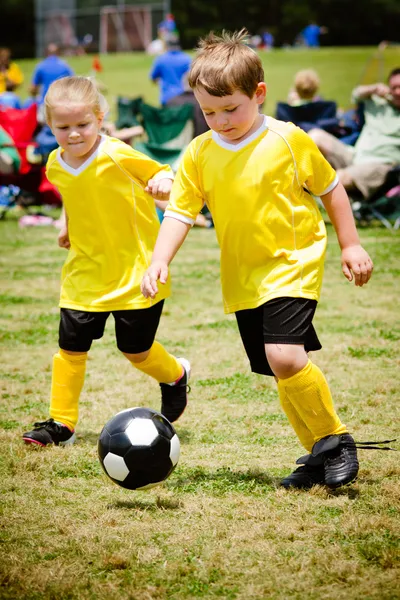 Дети, играть в футбол в игре организованной молодежи Стоковая Картинка